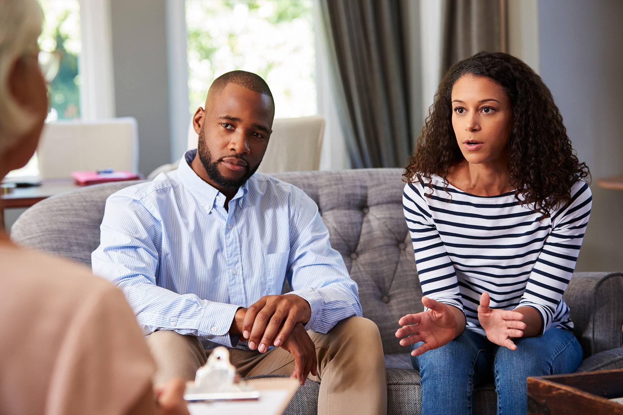 a married couple sitting down in an office interviewing a registered clinical counsellor to see if she is the right fit